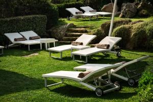 马达莱纳Grand Hotel Resort&SPA Ma&Ma - Adults Only的一群躺椅和椅子在草地上