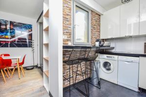 La VerrerieLuxe Neuilly s/ Seine的厨房设有洗衣机和烘干机,毗邻砖墙