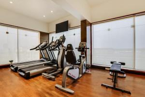 浦那Lemon Tree Hotel Viman Nagar Pune的一个带3台跑步机的健身房,位于带大窗户的房间里