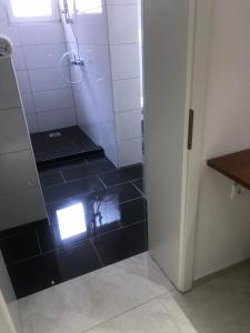 曼海姆Hotel Restaurant Memo的带淋浴的浴室,铺有黑色瓷砖地板。