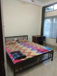 古瓦哈提Cozy Living的一间卧室配有一张带五颜六色棉被的床