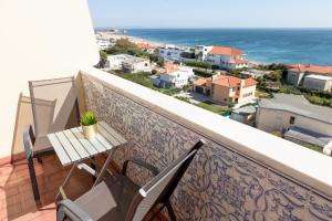 卡尔卡维洛斯Carcavelos Beach Hotel的一个带桌椅的海景阳台