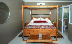 圣卢西亚伊瓜拉瓜拉宾馆的一间卧室配有一张带木制床架的床