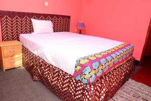吉塞尼MUHABURA MOUNTAIN LODGE的一间带一张大床的卧室,位于带桌子的房间