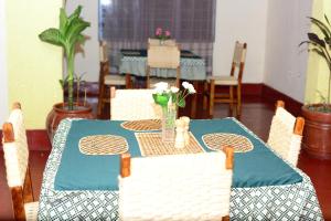 吉塞尼MUHABURA MOUNTAIN LODGE的一张桌子上放着蓝色桌布和鲜花