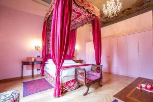 佛罗伦萨伽利略2000住宿加早餐酒店的一间卧室配有一张带粉红色窗帘的天蓬床