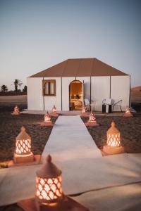梅尔祖卡Riad Kasbah Aiour的田野中间的帐篷,配有灯光