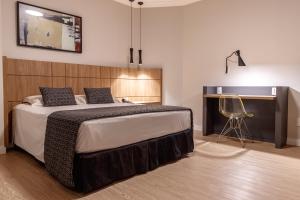 卡塔洛Mara Turismo Hotel的一间卧室配有一张带桌子和椅子的床