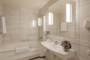 克莱佩达National Hotel的白色的浴室设有水槽和浴缸。