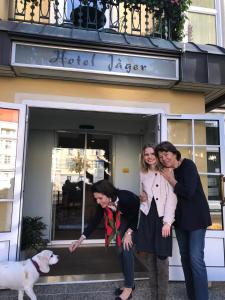 维也纳Hotel Jäger - family tradition since 1911的三个女人在一家商店前带着一只狗摆姿势