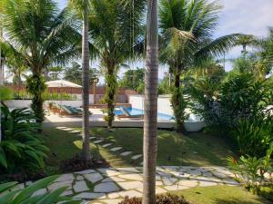 帕拉蒂Tropical Contemporary Suites的一个带游泳池和棕榈树的度假村