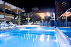 恩卡纳西翁日落酒店的夜间游泳池,带椅子和酒吧