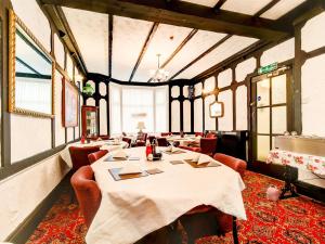 布莱克浦Thistle Dhu Guest House的用餐室设有桌椅和窗户。