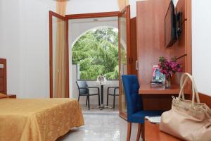 普拉亚·阿马勒Villaggio Turistico La Mantinera - Hotel的一间卧室配有一张床和一张桌子及椅子