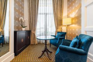 德拉托亚岛拉托哈欧洲之星酒店的酒店客房带蓝色椅子、桌子和窗户。