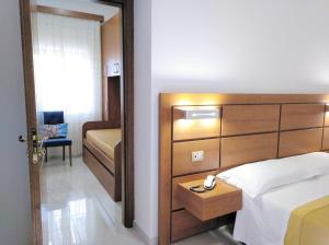 普拉亚·阿马勒Villaggio Turistico La Mantinera - Hotel的一间卧室配有一张带木制床头板的床
