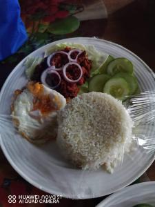 Batuanhome stay rizalina的米饭和蔬菜的白盘食物