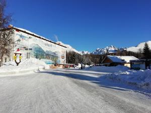 什特尔布斯凯普莱索Turistická ubytovňa SHB ,Štrbské Pleso - Vysoké Tatry的大楼前有雪覆盖的街道