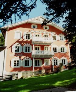 萨伦蒂诺Villa Lageder的一座大型的红色和白色建筑,设有阳台