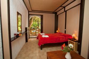 丹诺尼Damnoni Paradise的一间卧室配有红色的床和红色毯子
