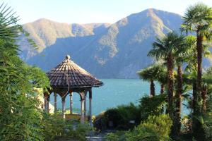 卢加诺Barony Le Pergole holiday apartments Lugano的享有湖泊和山脉美景的凉亭