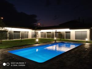 阿尔苏阿Carballos Altos-Apartamentos Turísticos的夜间在房子的院子中的一个游泳池