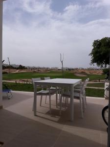 罗尔丹Las Terrazas Golf Resort Rental的庭院里摆放着白色的桌椅