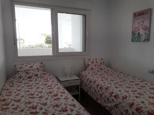 罗尔丹Las Terrazas Golf Resort Rental的一间卧室设有两张床和两个窗户。