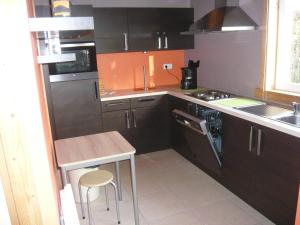 弗罗夏佩勒Bungalow的厨房配有棕色橱柜、桌子和水槽