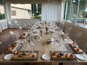瓦尔的圣卡西亚诺维拉埃巴罗恩斯Spa度假酒店的长桌,带餐盘和酒杯