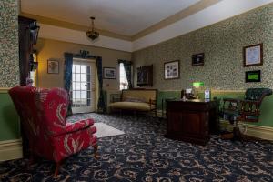 哈雷克Crown Lodge的客厅配有红色椅子和桌子