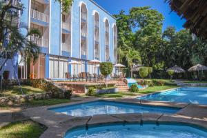 帕伦克Hotel Maya Palenque的大楼前的游泳池