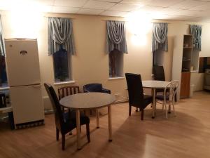 塔林Majaka Hostel的客房设有2张桌子和椅子以及窗户。