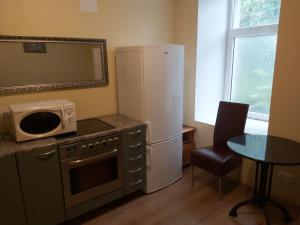 塔林Viva Nord Hotel的厨房配有冰箱和带微波炉的桌子。