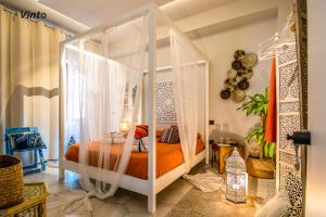 萨莱诺Vinto House Salerno Downtown的一间卧室配有带橙色床单的天蓬床