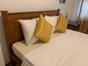 RagamaWhite House - Orange Hill Avenue的一张带四个黄色枕头的床