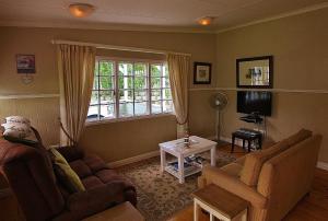 塞吉菲尔德Deja Vu Cottage的客厅配有沙发和桌子