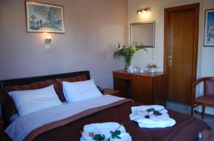 克桑西巴黎酒店的一间卧室配有带毛巾的床