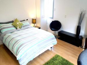 奥克兰奥克兰拉什与可欧住宿加早餐旅馆的一间卧室配有一张带绿白条纹毯子的床