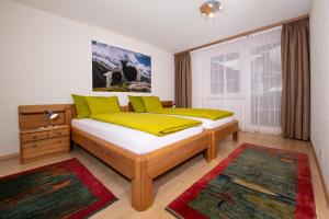 采尔马特灵气公寓的一间卧室配有两张带黄色和绿色枕头的床