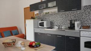 斯拉诺Apartmani Nena的一间带桌子和微波炉的小厨房