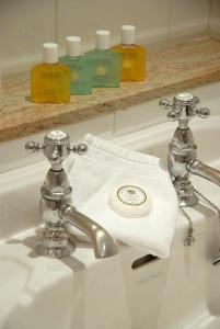 斯特兰拉尔西北城堡酒店的浴室水槽配有白色毛巾和水龙头