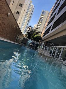 桑托斯Apart Estanconfor Santos的一座游泳池,位于一些高楼前
