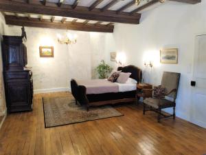 BalsacChateau de Balsac的一间卧室配有一张床和一把椅子