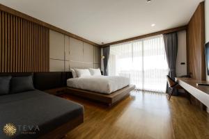 清莱TEVA Valley Resort的一间卧室配有一张床、一张沙发和一个窗口