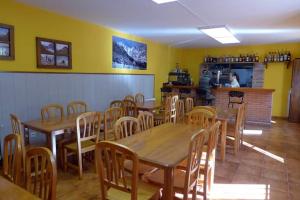 卡马莱尼奥Albergue La Vargona的餐厅设有木桌、椅子和柜台