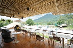 KiriwongPassion Resort Kiriwong的一间带桌椅并享有河景的餐厅