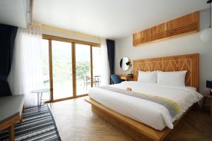KiriwongPassion Resort Kiriwong的一间卧室设有一张大床和一个大窗户