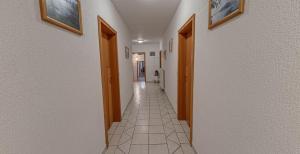 热尼亚波尔萨瓦歌乐埠酒店的走廊设有两扇门,铺有瓷砖地板