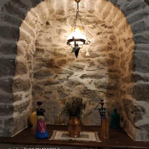 番红花城Nimet Hanım Konağı的吊灯挂在一堵石墙的房间里